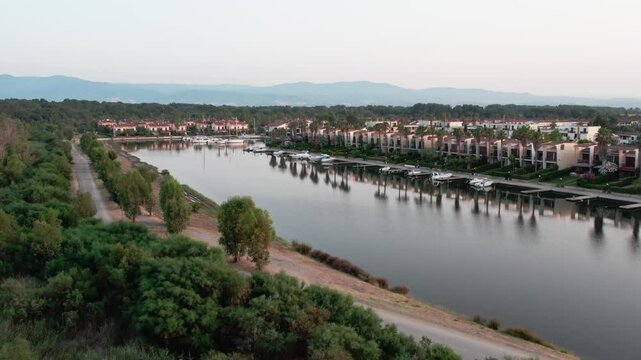 A drone over a small town on a lake. Marinas, Cloudy summer sunset. Sibari, Italy.