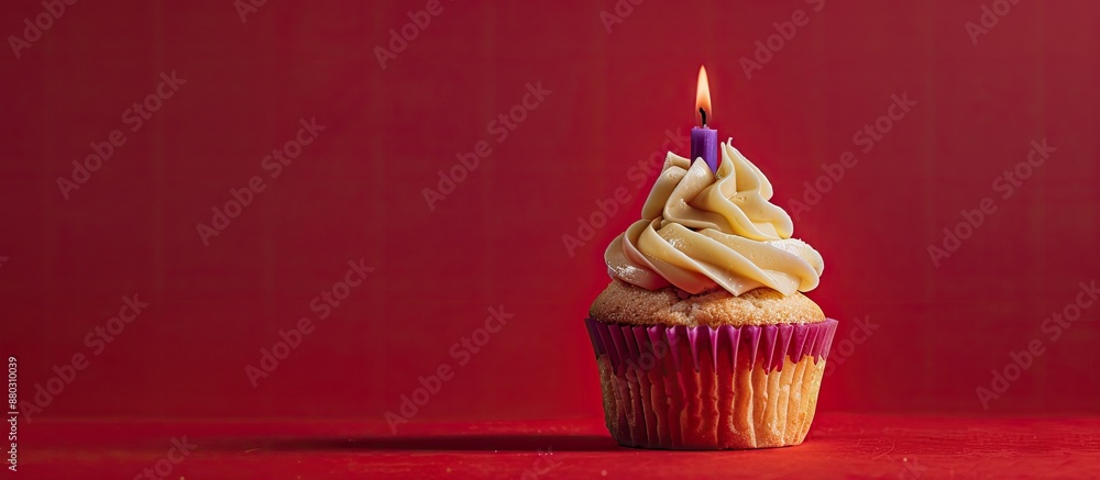 Poster a caramel cupcake topped with a lone purple candle displayed against a red background, providing amp