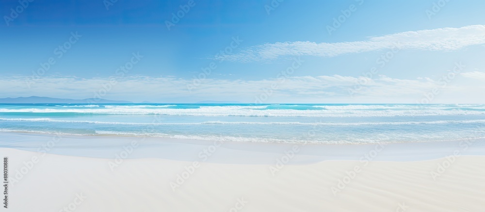 Aufkleber Beach waves during low tide against a clear blue sky with a vast expanse of sand, creating a serene and picturesque scene for a copy space image.