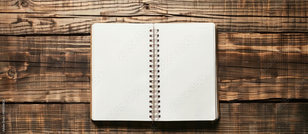 Poster wooden table displaying a notepad with empty white pages, offering ample copy space image.