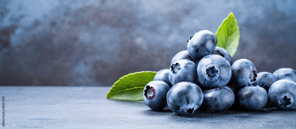 Poster Close-up macro image of a blueberry on a table against a blue concrete background, designed with space for text or other elements.