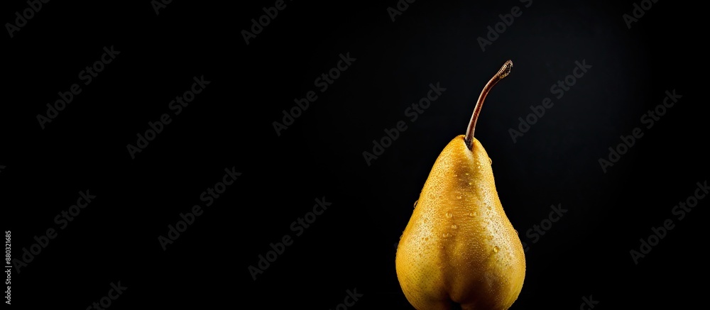 Poster ripe pear against black backdrop with copy space image.
