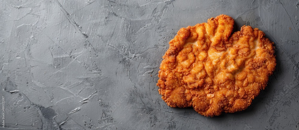 Poster Top view of a Breaded German Weiner Schnitzel on a gray background, with space for text or other elements in the image.