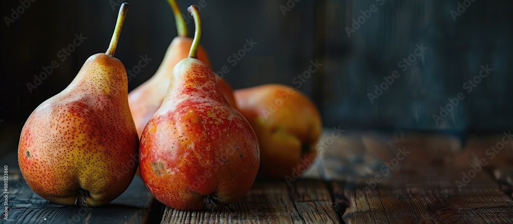 Aufkleber ripe pears displayed on a wooden table with a dark background, providing a copy space image.
