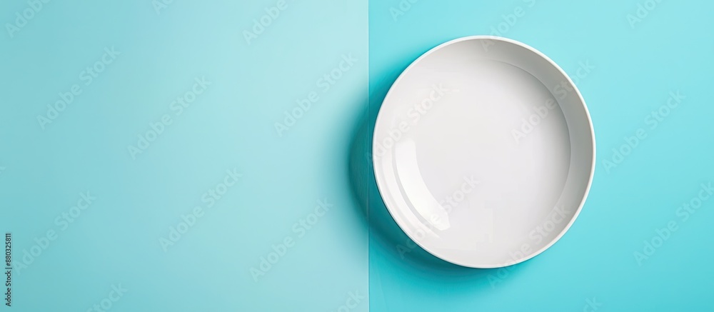Poster top view of an empty white plate on a blue background table with copy space image.