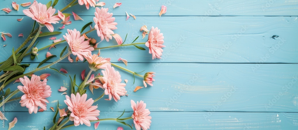 Poster card mockup with floral decor on a blue wooden background and greeting card mockup featuring pink fr