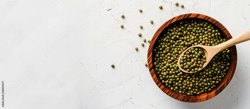 Poster mung beans in a wooden bowl with a spoon on a white background ample copy space available in the ima