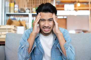 young men has headache and dizzy his hands rubbing on temple from hangover