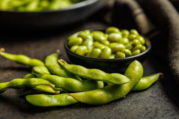 Green edamame pods. Fresh soybeans on black table.