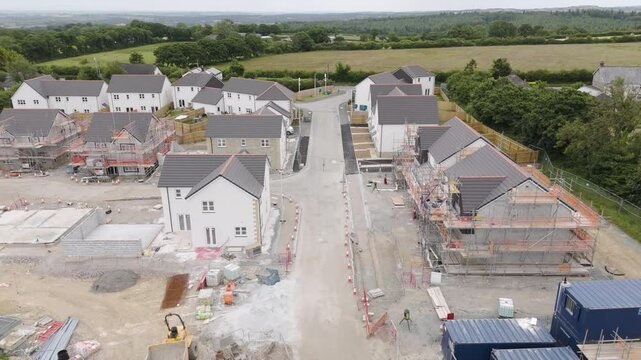 Drone view of a new housing estate partially built in Devon, UK, highlighting the construction progress and surrounding fields