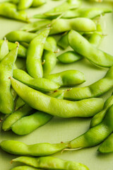 Green edamame pods. Fresh soybeans on green table.