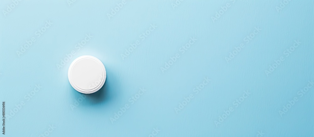 Poster healthcare related white circular pill displayed on a blue background with ample copy space image