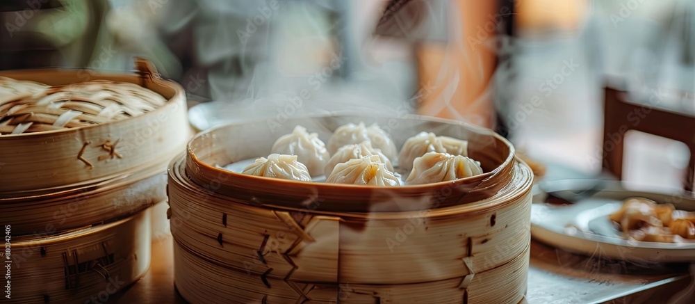 Poster blurry steamed dumplings in a bamboo steamer sit on a dining table in a chinese restaurant surrounde