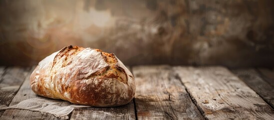A rustic loaf of bread sits on a weathered wooden table with a vintage look providing a charming scene with copy space image