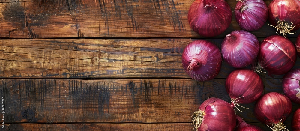 Aufkleber Red Onions on a bright wooden surface creating a backdrop for text with a focused view from above suitable for a copy space image