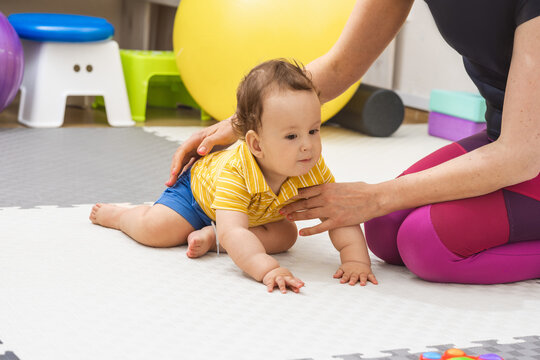 Physical therapist helps a young boy develop his motor skills