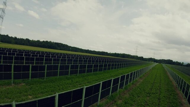 Drone flying above the agricultural field and photovoltaic system, solar panels installed in rows between the fields, Styria, Austria