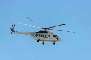 Big offshore civil transport helicopter is flying rotary-wing aircraft fireproof steel cowlings blue sky