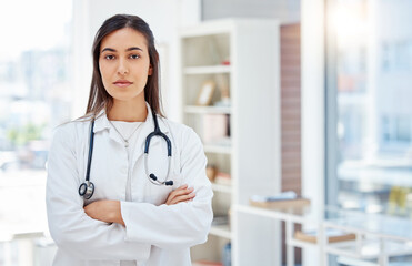 Portrait, woman and doctor with arms crossed, healthcare and career ambition in hospital. Serious face, person or medical with professional, stethoscope or attitude with confidence or pride in clinic