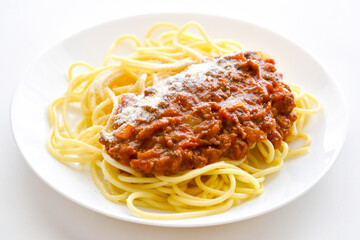Spaghetti Bolognese with minced beef, onion, chopped tomato, garlic, olive oil, stock cube, tomato puree and Italian herb. Traditional Italian food on a plate. 