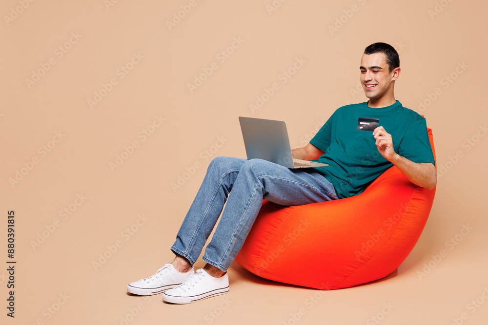 Wall mural full body young it man wear blue t-shirt casual clothes sit in bag chair using laptop pc computer ho