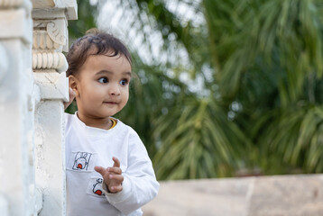 cute toddler innocent portraits at temple courtyard at day from unique perspective
