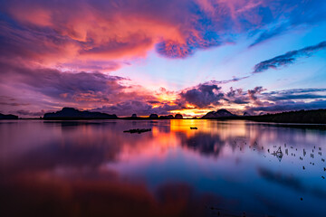 Obraz premium Landscape Long exposure of majestic clouds in the sky sunset or sunrise over sea with reflection in the tropical sea.Beautiful cloudscape scenery.Amazing light of nature Landscape nature background