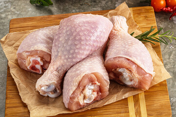 Raw uncooked chicken drumsticks over board