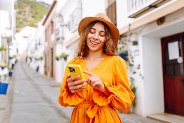 A female traveler in a beautiful yellow dress is sightseeing in European cities. Traveler with a...