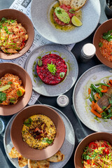 Table scene of assorted take out or delivery foods. Hamburgers, pizza, fried chicken and sides. Top down view on a dark wood banner background.