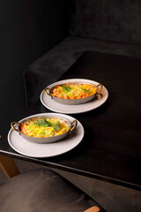 Table scene of assorted take out or delivery foods. Hamburgers, pizza, fried chicken and sides. Top down view on a dark wood banner background.