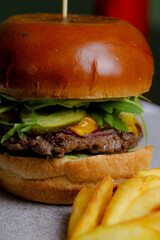Table scene of assorted take out or delivery foods. Hamburgers, pizza, fried chicken and sides. Top down view on a dark wood banner background.