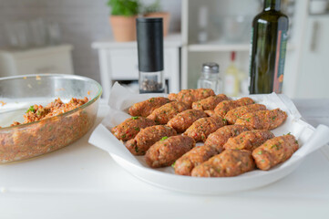 Homemade food. Fresh and raw cevapcici or meat rolls on kitchen counter