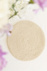 Bouquet of purple and white carnations and gypsophila on table setting with beige wicker napkin. Top View from above