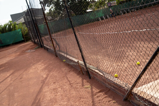 friends playing social tennis club on a clay tennis court in summer