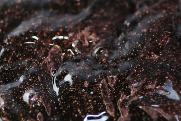 Macro shot of bronze and gold particles in water