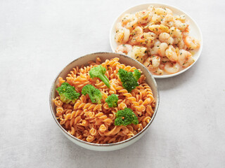 healthy dishes on the table for a low carbohydrate diet. Legume pasta with red lentils, broccoli florets and garlic shrimp.