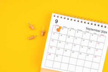 September 2024 Monthly desk calendar for 2024 year with wooden pin on yellow background.