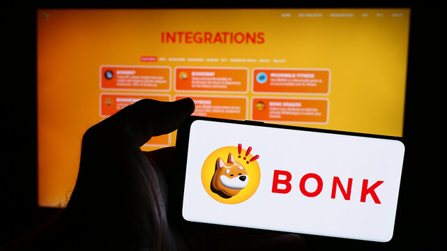 Stuttgart, Germany - 07-05-2024: Person holding mobile phone with logo of dog coin company Bonk Inu in front of business web page. Focus on phone display.