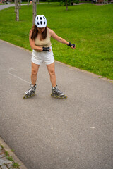 Roller skater woman in park rollerblading on inline skates. Outdoor activities. Summer roller...