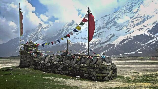 Mani prayer wall with Buddhist prayer flags in the wind with a panorama of the mountains of Pungyen Gompa, Annapurna, Nepal