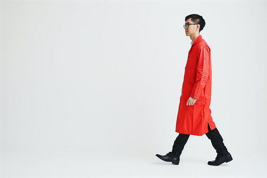 confident male Singapore Polytechnic chemical science student in red stylish lab coat walking in pure white background