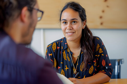Aboriginal woman talking to a man with glasses in an office - Powered by Adobe