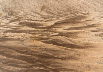 Natural texture: top view of beach sand, clear, clean and smooth. Minimalist background for summer concepts, travel, vacations and outdoor enjoyment.