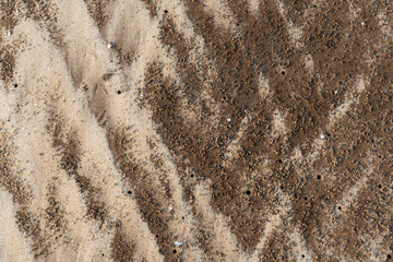 Natural texture: top view of beach sand, clear, clean and smooth. Minimalist background for summer concepts, travel, vacations and outdoor enjoyment.