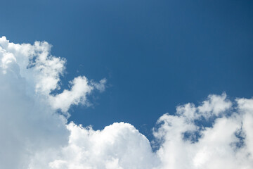 Texture of blue sky with white clouds on one side on a clear day