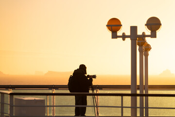 Sunset Antarctica Cruise Ship Male Passenger Professional Photographer in Warm Hat Telephoto Lens...