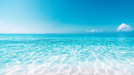 Crystal clear turquoise waters and bright blue sky at a tranquil beach, perfect for a relaxing tropical getaway or background image.