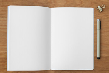 Blank notebook page with a bulldog clip and a pen design element