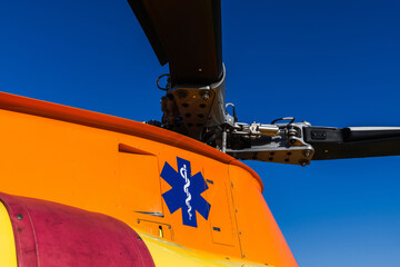 Top of a medical helicopter with medical sign down the propellers